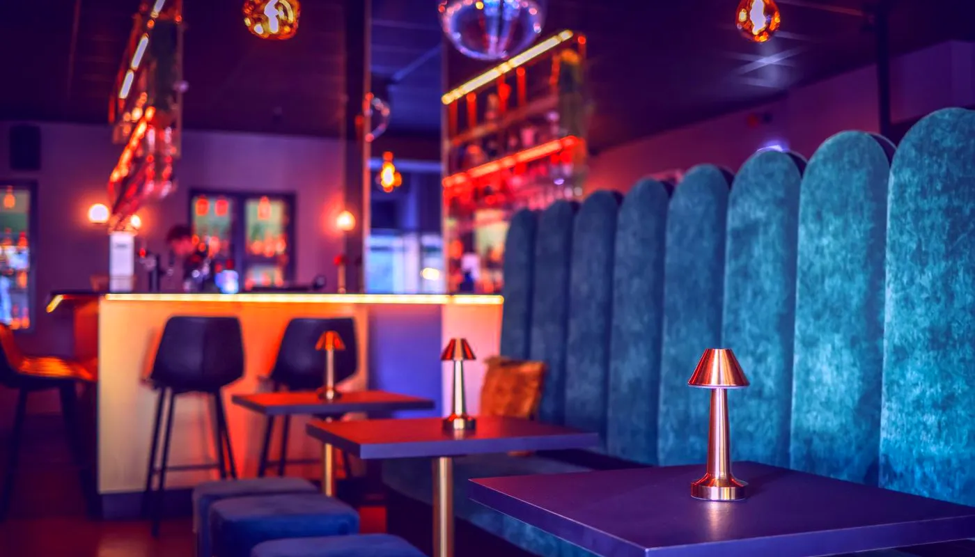 Low-lit lounge with velvet booths and a mirror ball